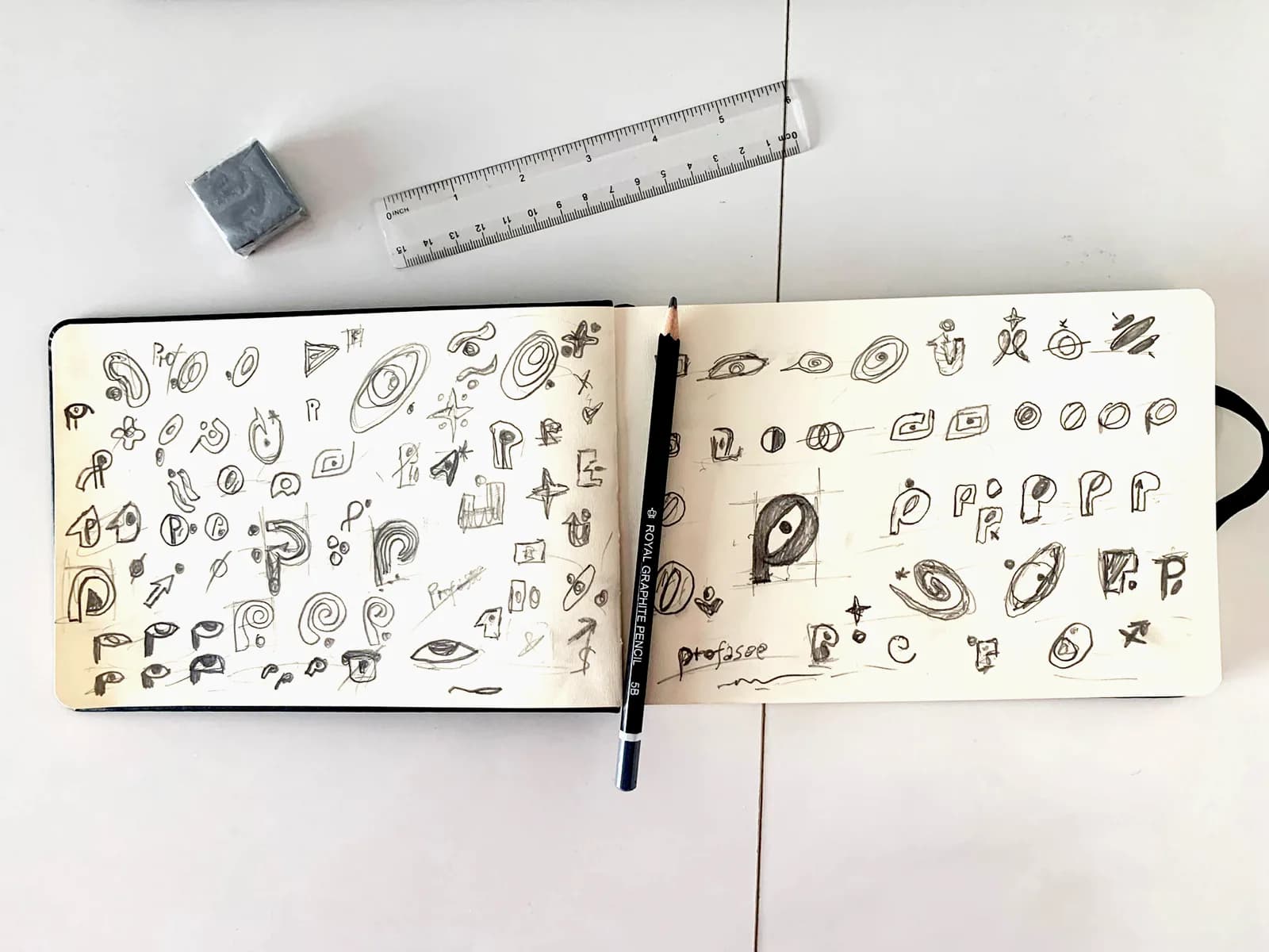 Open sketchbook with early Profasee logo studies and symbol explorations